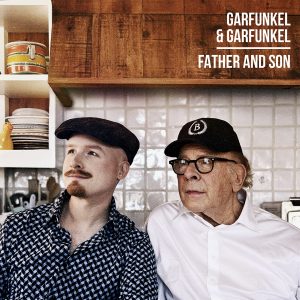 Art Garfunkel senior with Art Garfunkel junior looking off to the side in what looks like a kitchen.